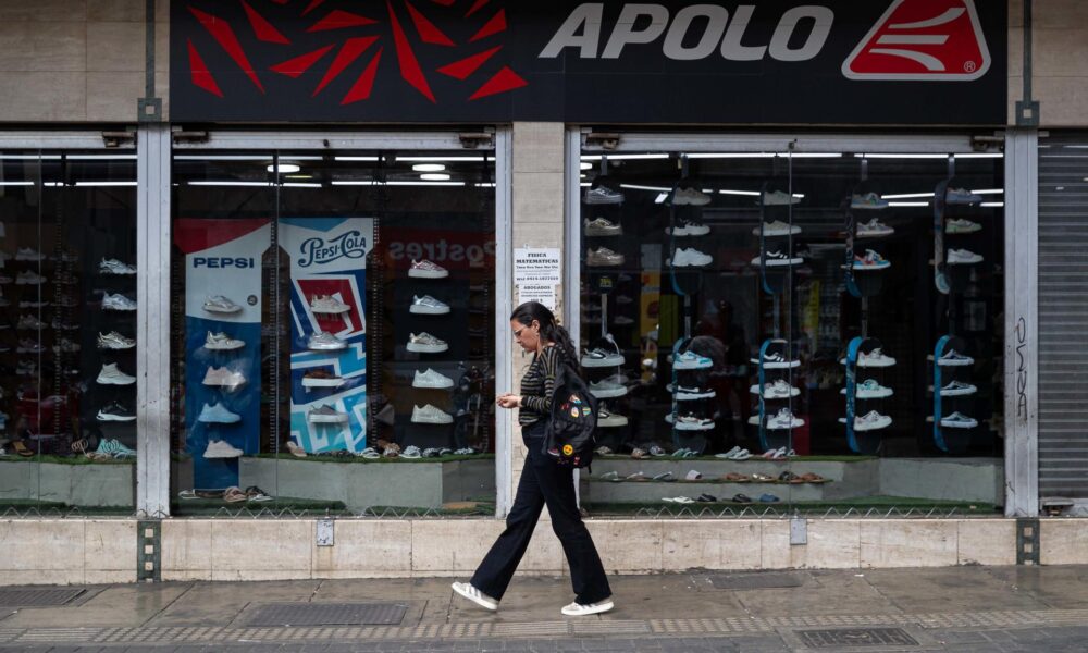 AME1314. CARACAS (VENEZUELA), 14/01/2025.- Una mujer camina frente a un comercio este martes, en Caracas (Venezuela). Venezuela volvió a una relativa normalidad, luego de una semana de escasa actividad económica y educativa debido, en buena parte, a las protestas chavistas y opositoras previas a la toma de posesión presidencial, con un amplio despliegue militar y policial en las calles, y a la cuestionada investidura de Nicolás Maduro para un tercer mandato consecutivo. EFE/ Ronald Peña R.