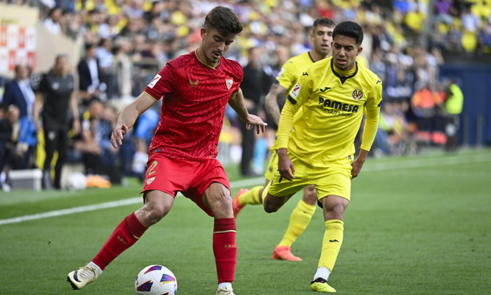 El defensa del Sevilla Kike Salas (i) pelea un balón con el centrocampista del Villarreal Ilias Chakkour (d) durante el partido de la trigésima quinta jornada de la pasada Liga. EFE/ Andreu Esteban