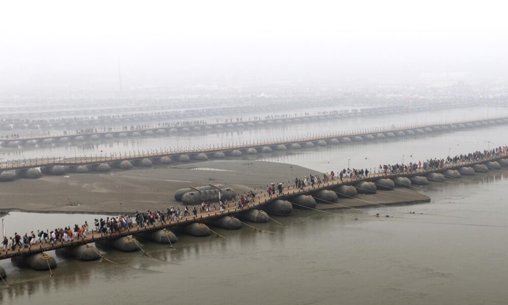 Los fieles hindúes cruzan puentes pontones en el primer día del festival Kumbh Mela en Sangam, la confluencia de los ríos sagrados Ganges, Yamuna y Saraswati, en Prayagraj, estado del norte de Uttar Pradesh, India, 13 de enero de 2025. 
EFE/EPA/RAJAT GUPTA