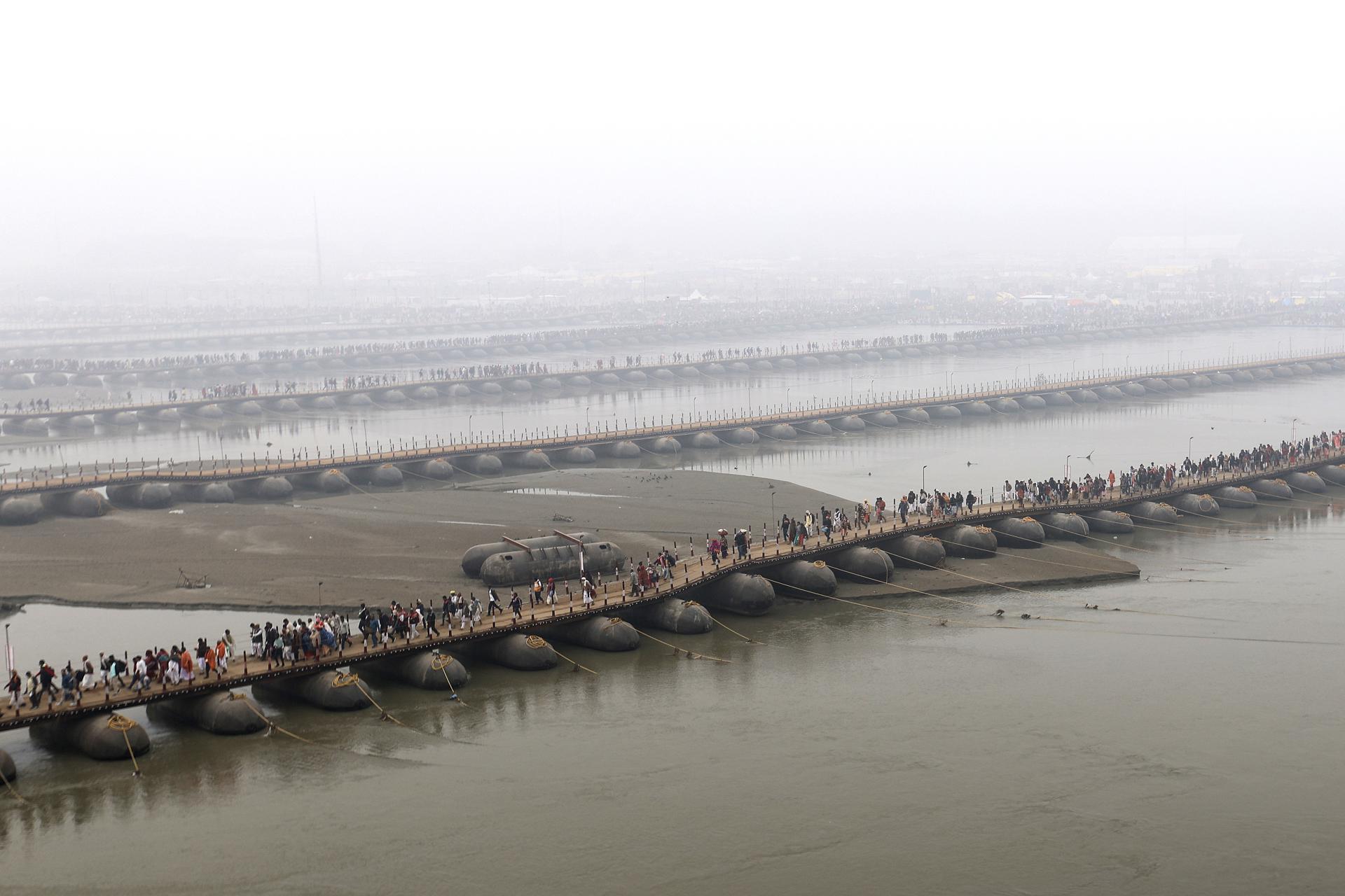 Los fieles hindúes cruzan puentes pontones en el primer día del festival Kumbh Mela en Sangam, la confluencia de los ríos sagrados Ganges, Yamuna y Saraswati, en Prayagraj, estado del norte de Uttar Pradesh, India, 13 de enero de 2025. 
EFE/EPA/RAJAT GUPTA