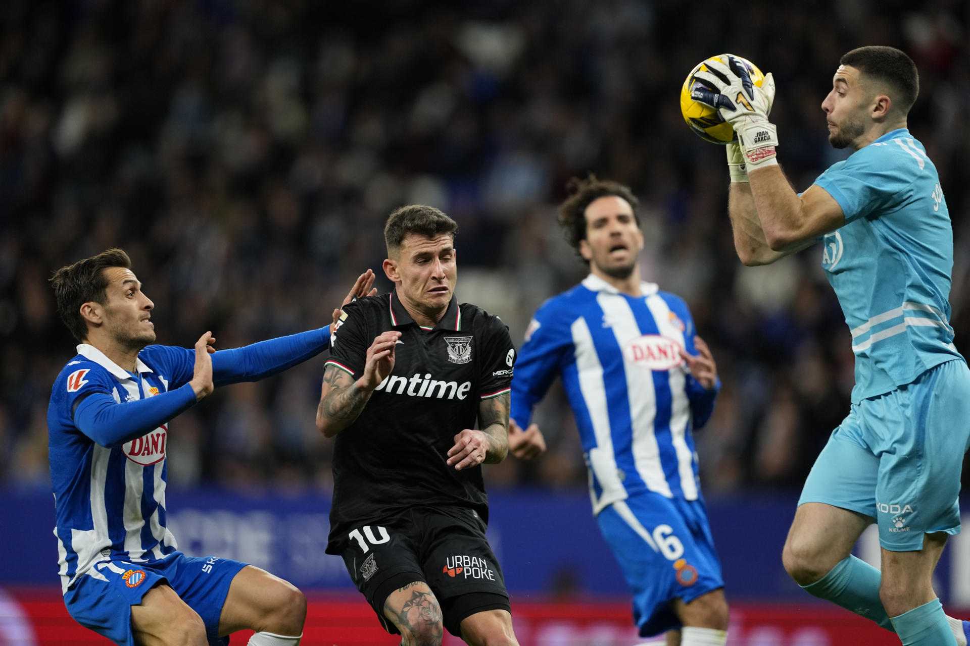 El portero del Espanyol Joan García (d) atrapa el balón ante el centrocampista del Leganés Raba (2i) en el partido de LaLiga entre el Espanyol y el Leganés, este sábado en el estadio RCDE Stadium. EFE/ Alejandro Garcia