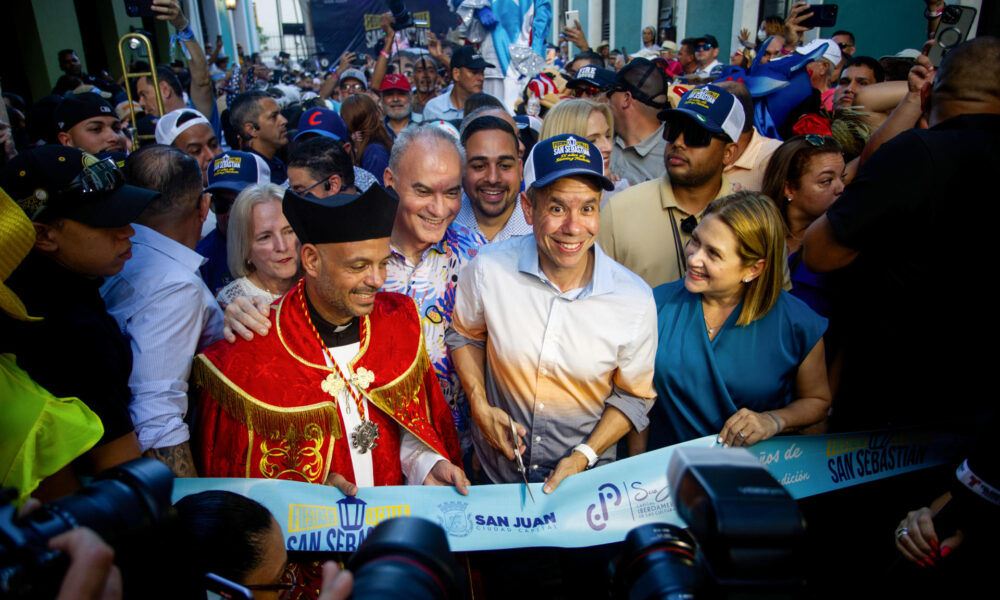 El alcalde de San Juan, Miguel Romero (c) y el capellán de la Catedral de San Juan, el padre Benjamín Pérez (i), cortan la cinta de la inauguración de la edición 55 de las Fiestas de la Calle San Sebastián este jueves, en San Juan (Puerto Rico). EFE/ Thais Llorca