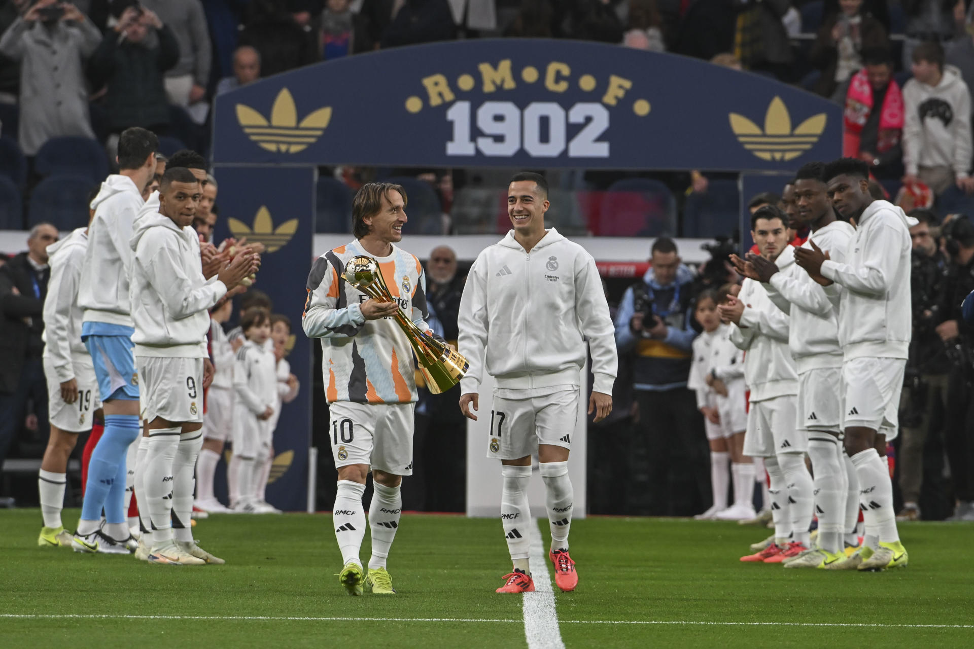 Los jugadores del Real Madrid Luka Modric (c-i) y Lucas Vázquez (c-d) muestran al público el Trofeo de la Copa Intercontinental,en el estadio Santiago Bernabéu en foto de archivo de Fernando Villar. EFE