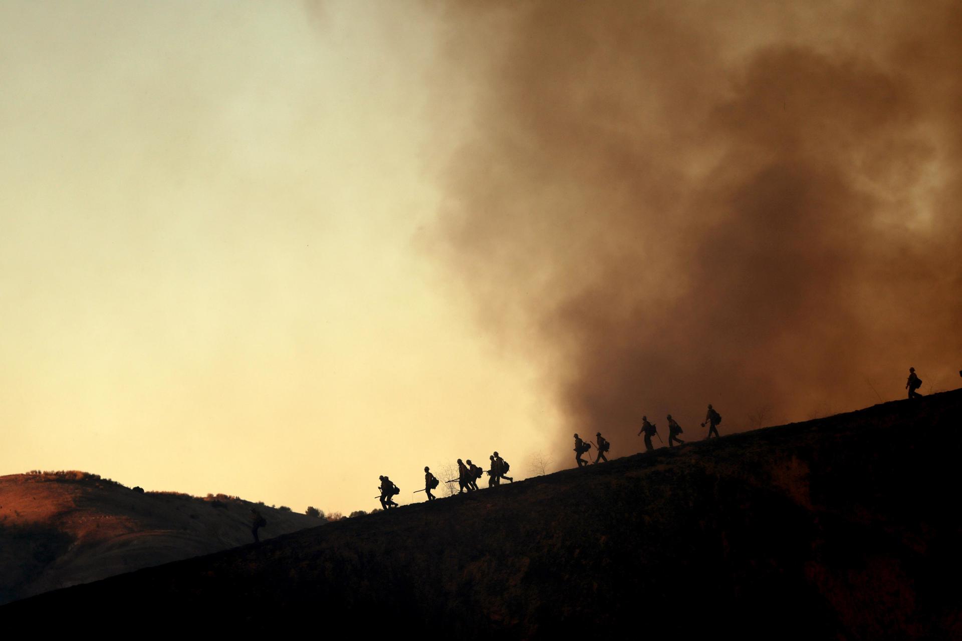 Los bomberos toman posiciones para combatir el incendio Kenneth en el vecindario de Woodland Hills en Los Ángeles, California, EE. UU. EFE/ALLISON DINNER