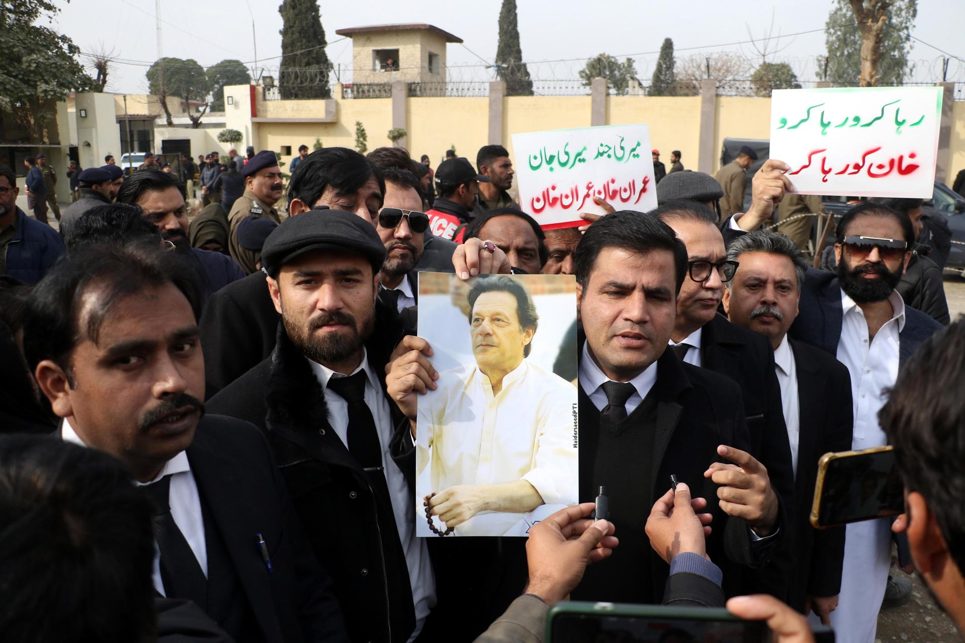 Simpatizantes del partido de oposición Pakistán Tehreek-e-Insaf (PTI) sostienen una fotografía del fundador del PTI, el ex primer ministro Imran Khan, condenado este viernes a 14 años de cárcel por recibir tierras a modo de soborno haciendo uso indebido de su cargo durante su mandato. EFE/EPA/SOHAIL SHAHZAD