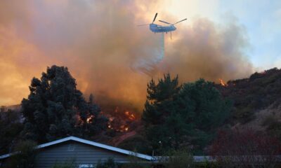 Un helicóptero arroja agua sobre una casa durante el incendio forestal de Palisades en Los Ángeles, California (EE.UU.). EFE/ALLISON DINNER