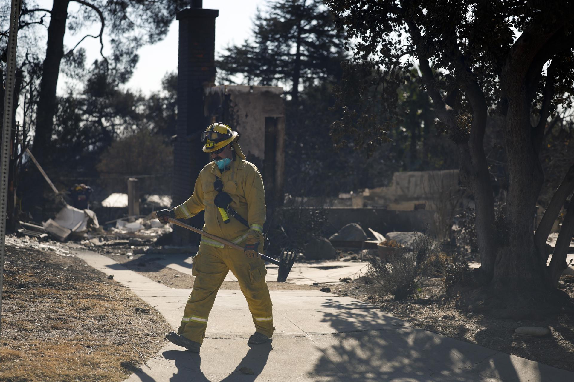 Bomberos y equipos de búsqueda y rescate inspeccionan el lugar de una casa incendiada en Altadena, California, EE.UU. EFE/EPA/CAROLINE BREHMAN