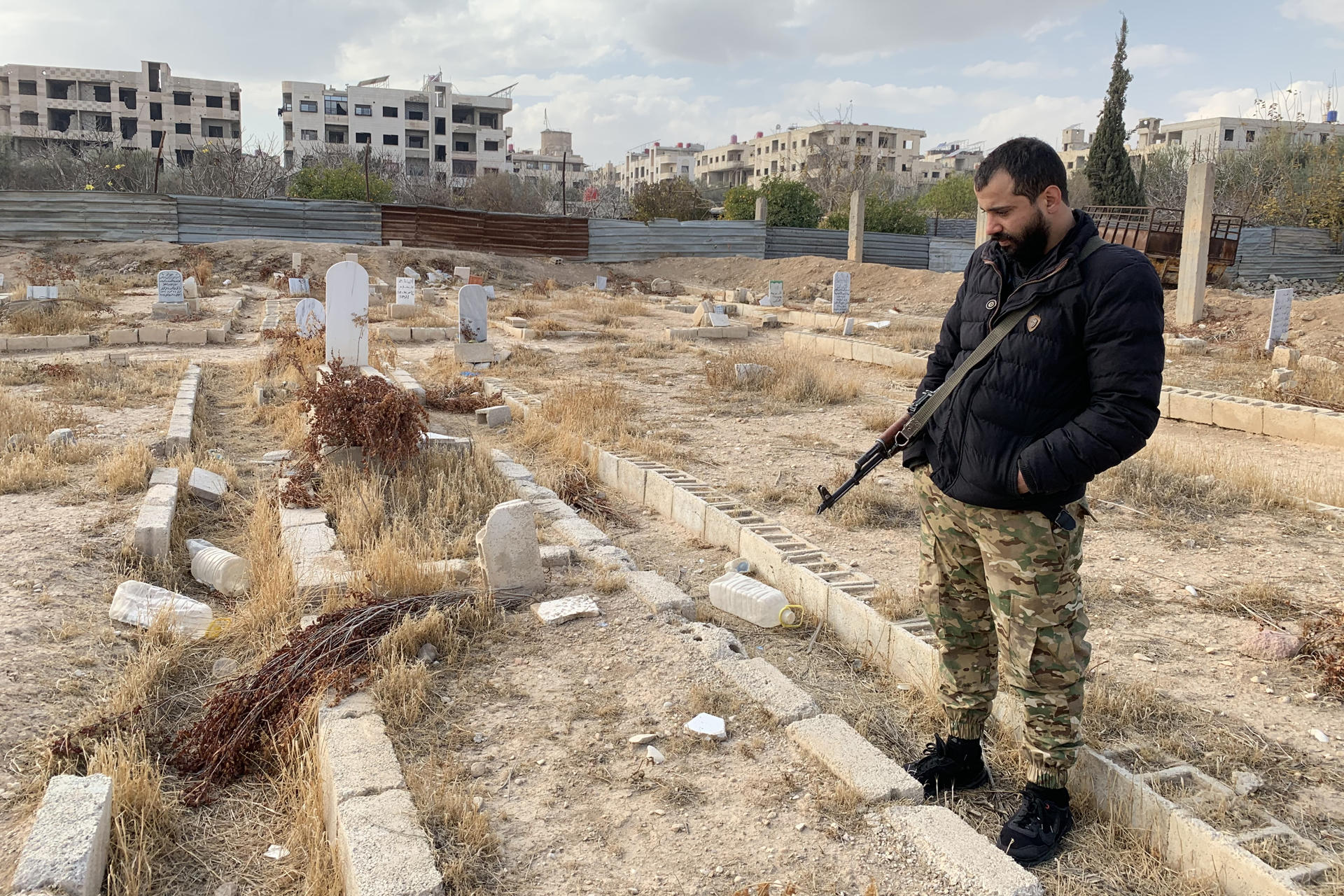 Imagen del combatiente Saif el Din al Dahla frente a la tumba de sus familiares muertos en el ataque químico de 2013 en Zamalka, a las afueras de Damasco, el 26 de diciembre de 2024. EFE/Noemí Jabois