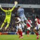 El portero del Arsenal David Raya (I) tapa huecos ante el remate de Dominic Solanke, del Tottenham, (c) durante el partido de la Premier League que han jugado Arsenal FC y Tottenham Hotspur, en Londres Reino Unido. EFE/EPA/DAVID CLIFF