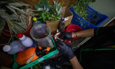 El curandero ecuatoriano Ismael mezcla hierbas para un ritual para recibir el nuevo año 2025 este martes 31 de diciembre, en un local de curanderos en Quito (Ecuador). EFE/ José Jácome