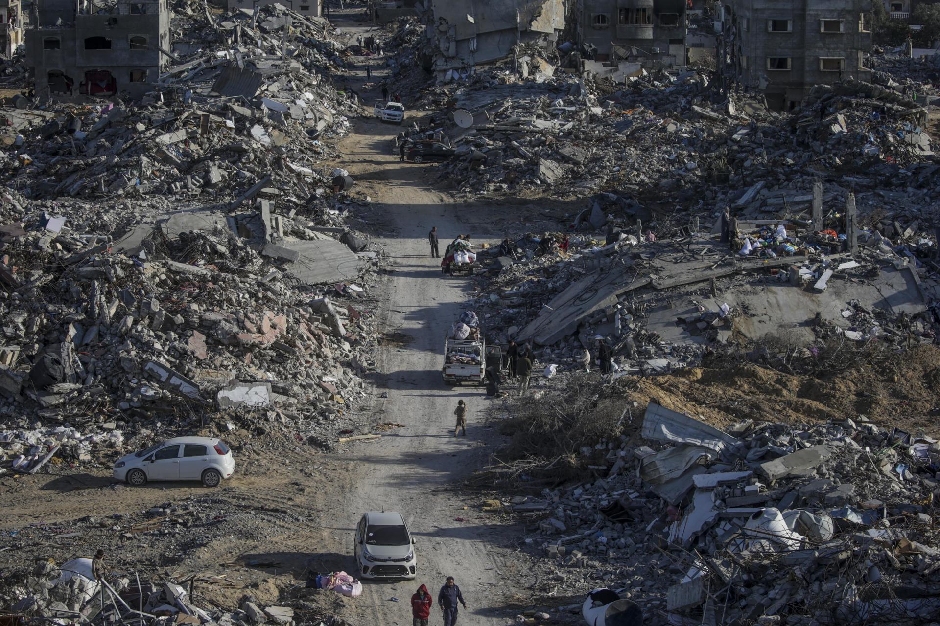 Palestinos inspeccionan los edificios destruidos en el campo de refugiados de Rafah, en el sur de Gaza, el 20 de enero de 2025, tras alcanzarse el alto el fuego en la zona. EFE/EPA/MOHAMMED SABER