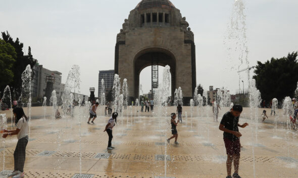 Personas juegan en una fuente del Monumento a la Revolución en la Ciudad de México (México). EFE/ Mario Guzmán