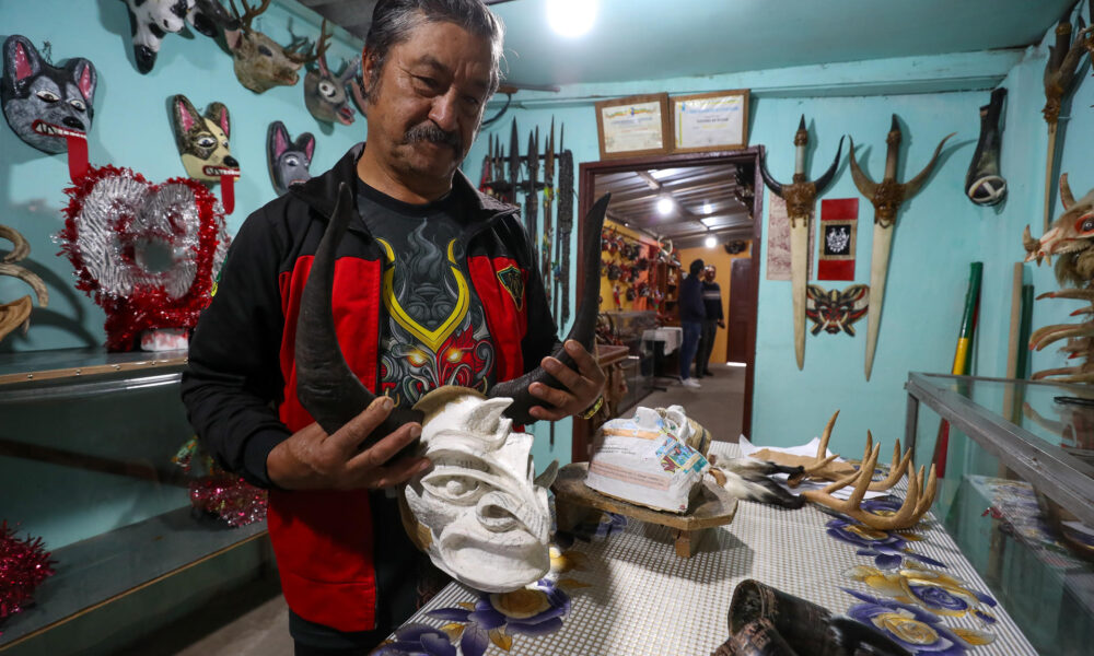 Fotografía del 6 de enero de 2025 del artesano Ángel Velasco observando una mascara en Píllaro (Ecuador). EFE/José Jácome