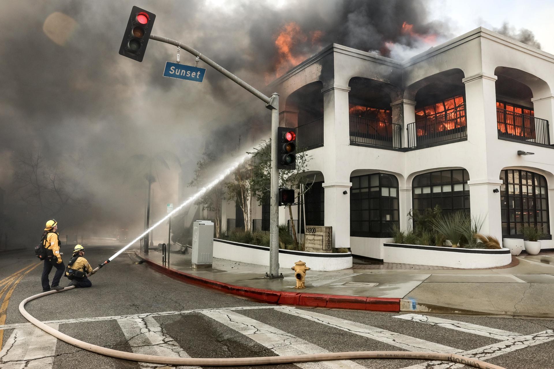 Los bomberos luchan contra las llamas que envuelven un edificio durante el incendio forestal de Palisades en el barrio de Pacific Palisades de Los Ángeles, California (EE.UU.). EFE/ALLISON DINNER