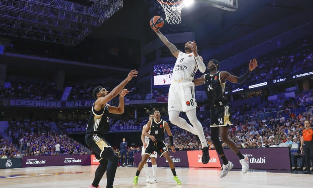 El alero estadounidense del Real Madrid Chuma Okeke (c) entra a canasta ante dos rivales del Asvel durante el partido de la tercera jornada de la temporada regular de la Euroliga que disputan este jueves en el Movistar Arena de Madrid. EFE/Juanjo Martín