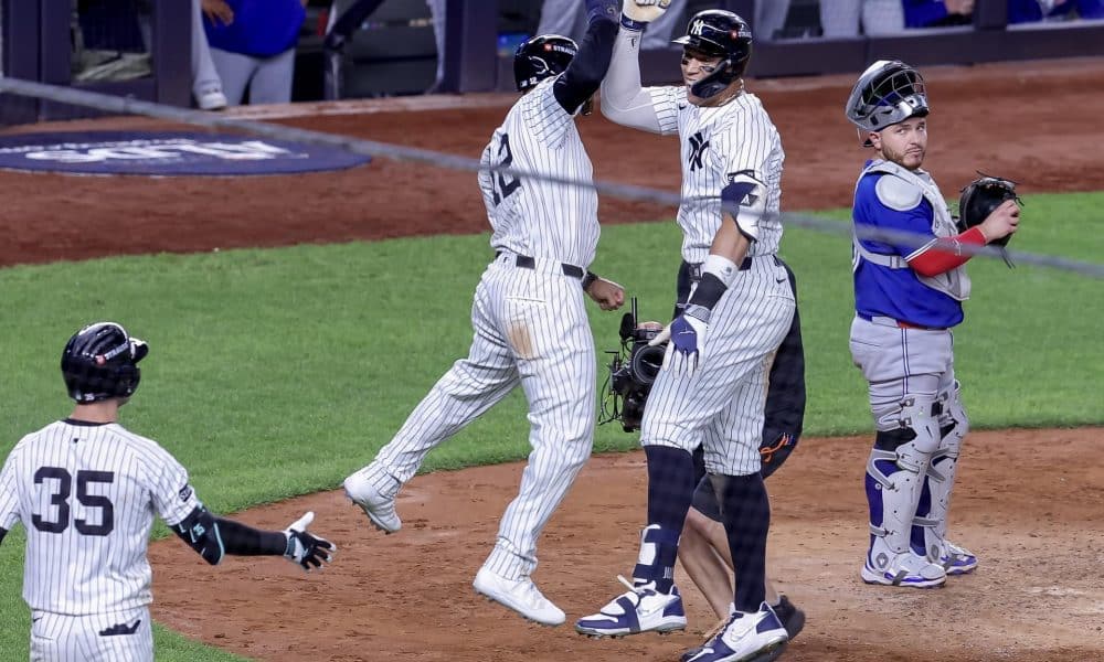 El jardinero derecho de los New York Yankees, Aaron Judge (C), celebra con el jardinero central, Trent Grisham (I), después de conectar un jonrón de tres carreras, mientras el receptor de los Toronto Blue Jays, Alejandro Kirk (D), observa en la cuarta entrada del juego 3 de la serie de playoffs de la División Americana de la MLB. EFE/EPA/SARAH YENESEL