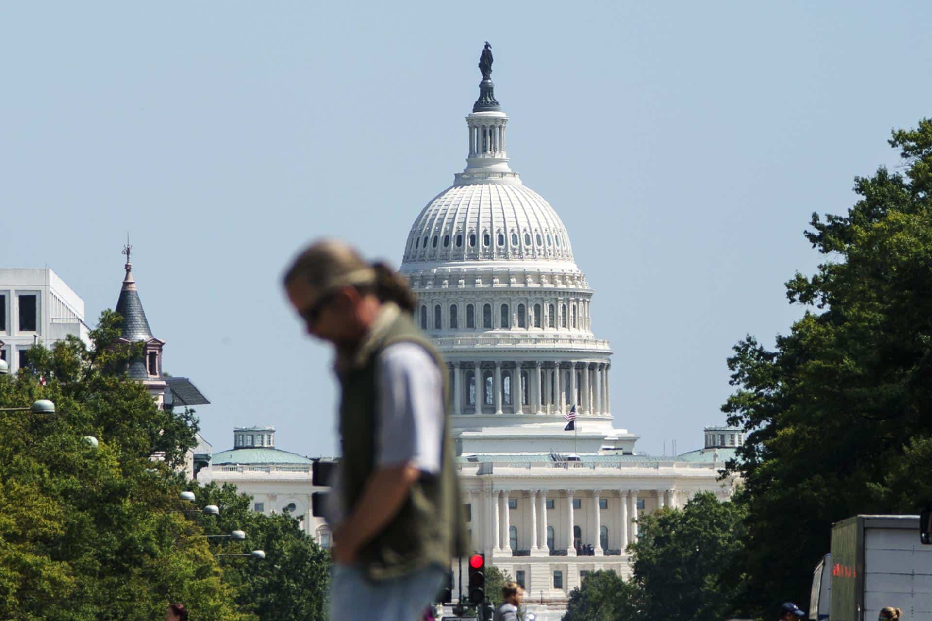 Foto de archivo que muestra a un transeúnte cruzando la avenida Pensilvania frente al Capitolio de los Estados Unidos, en Washington D. C. EFE/EPA/WILL OLIVER