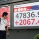 Un transeúnte fue captado este lunes, 6 de octubre, al observar una pantalla con los índices del mercado de valores de la Bolsa de Tokio, donde su principal indicador, el Nikkei, alcanzó su máximo histórico intradía (47.873,4 puntos), en Tokio (Japón). EFE/Franck Robichon