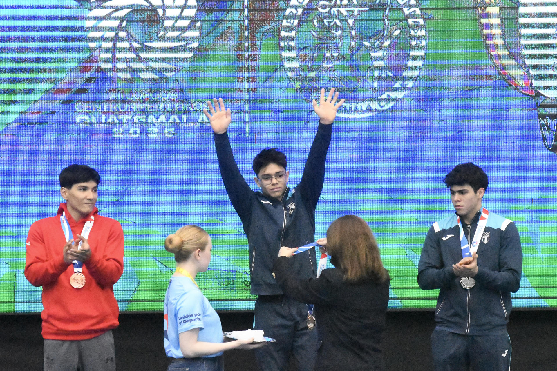 Jaycko Bourdet (c), de Guatemala, recibe la medalla de oro al ganar en la gimnasia artística en modalidad all around este viernes en los Juegos Centroamericanos Guatemala 2025. EFE/Alex Cruz