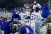 El bateador designado de Los Angeles Dodgers, Shohei Ohtani (c), es recibido en el dugout después de anotar contra los Azulejos de Toronto durante la quinta entrada del tercer partido de la Serie Mundial. EFE/EPA/ALLISON DINNER