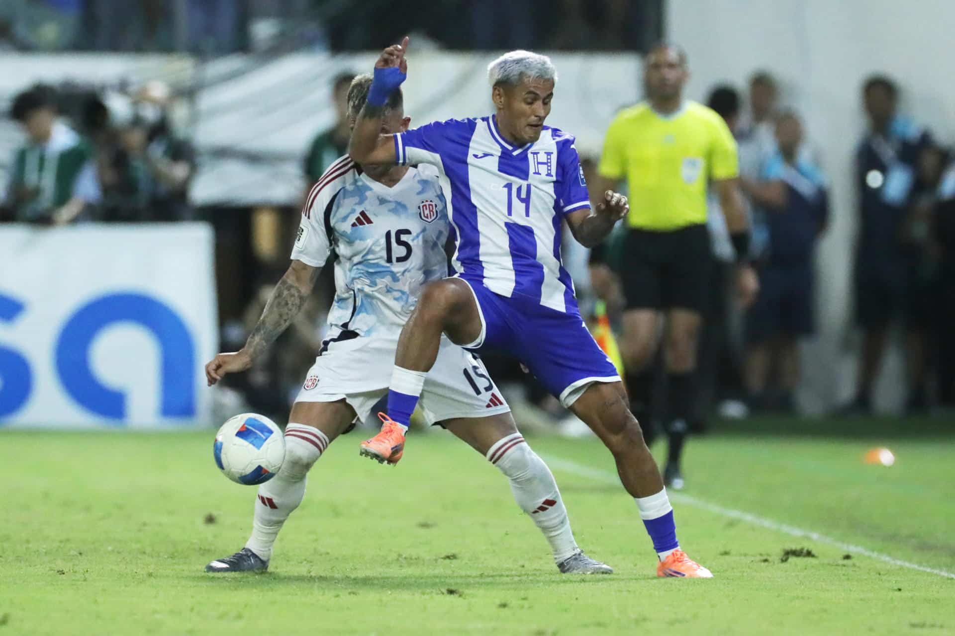 El hondureño Andy Najar (d) disputa un balón con el costarricense Francisco Quesada durante el partido de la tercera jornada del Grupo C de las eliminatorias de la Concacaf para el Mundial de 2026 jugado este jueves en el Estadio General Francisco Morazán, de San Pedro Sula. EFE/ Gustavo Amador