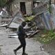 Una persona camina frente a una casa afectada por el paso del huracán Melissa este martes, en Kingston (Jamaica). EFE/Rudolph Brown