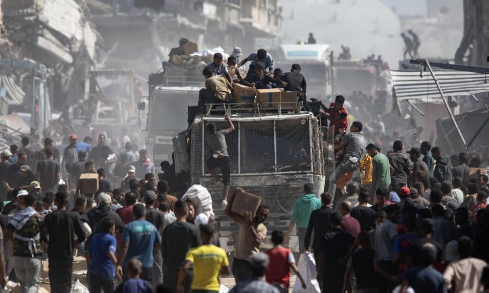 Palestinos alrededor de camiones con ayuda humanitaria. EFE/HAITHAM IMAD