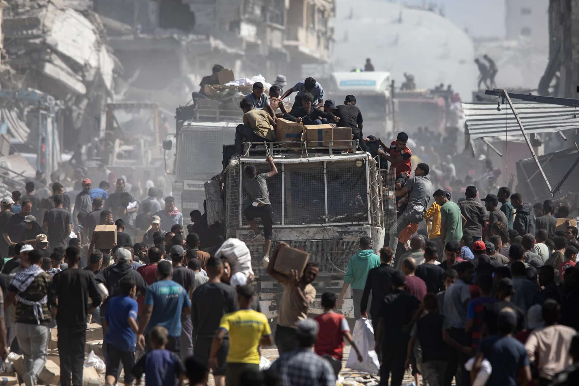 Palestinos alrededor de camiones con ayuda humanitaria. EFE/HAITHAM IMAD