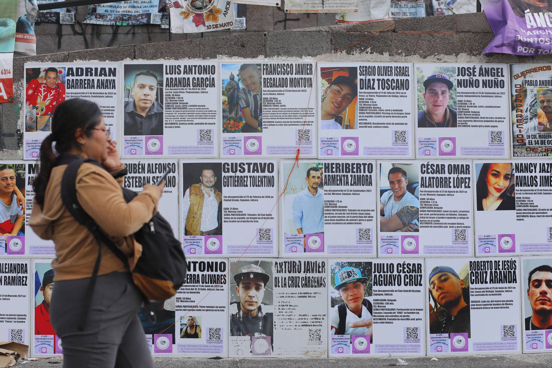 Una mujer pasa frente a carteles de búsqueda de personas este viernes, en la glorieta ‘Niños Héroes’, en Guadalajara (México). EFE/ Francisco Guasco