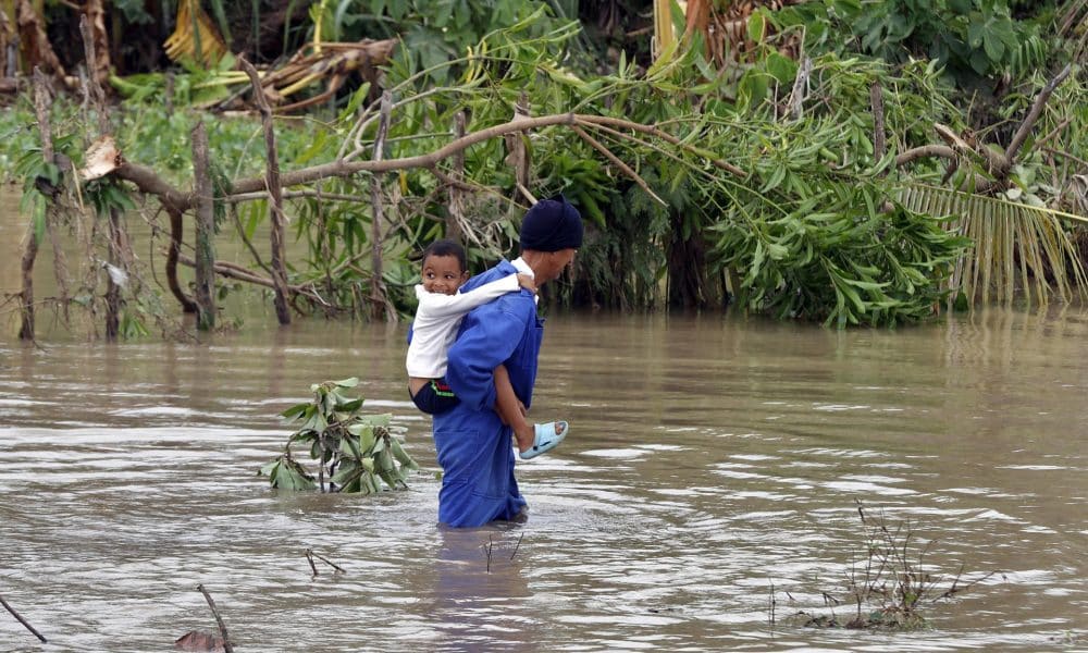 Un hombre fue captado este miércoles, 29 de octubre, al cruzar un río crecido mientras carga a un niño a sus espaldas, tras el paso del huracán Melissa, en el poblado de Guama, en Santiago de Cuba (Cuba). EFE/Ernesto Mastrascusa