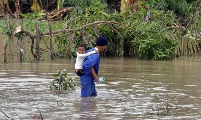 Un hombre fue captado este miércoles, 29 de octubre, al cruzar un río crecido mientras carga a un niño a sus espaldas, tras el paso del huracán Melissa, en el poblado de Guama, en Santiago de Cuba (Cuba). EFE/Ernesto Mastrascusa