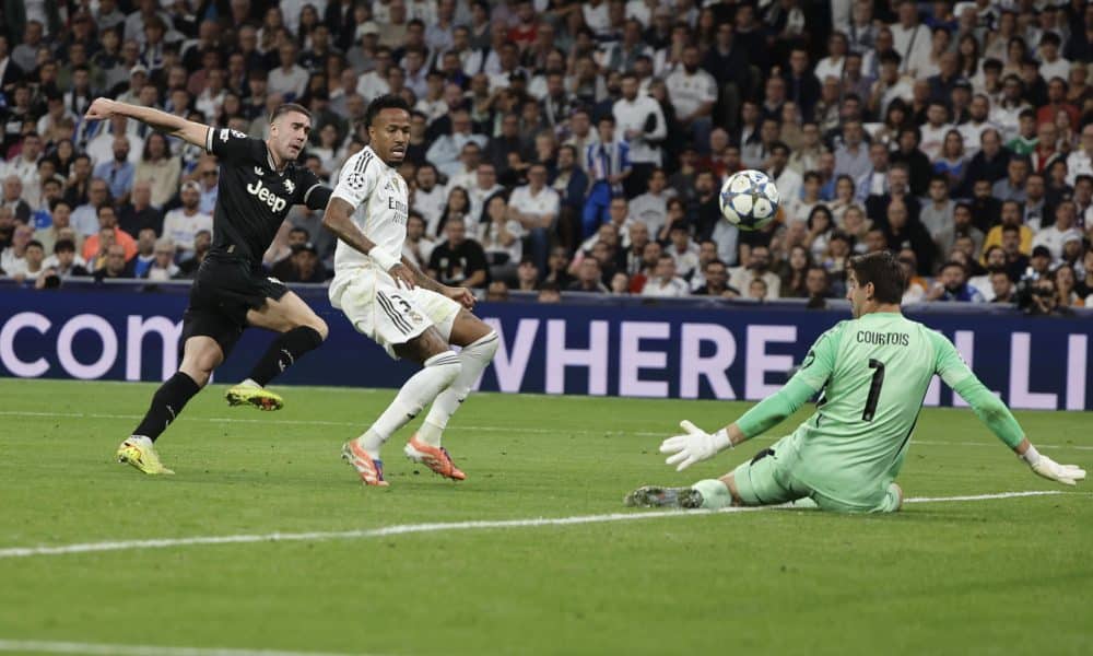 El portero del Real Madrid Thibaut Courtois (d) en acción este miércoles, durante el partido de la jornada 3 de la Liga de Campeones UEFA, entre el Real Madrid y la Juventus, en el estadio Santiago Bernabéu de Madrid. EFE/ Sergio Perez