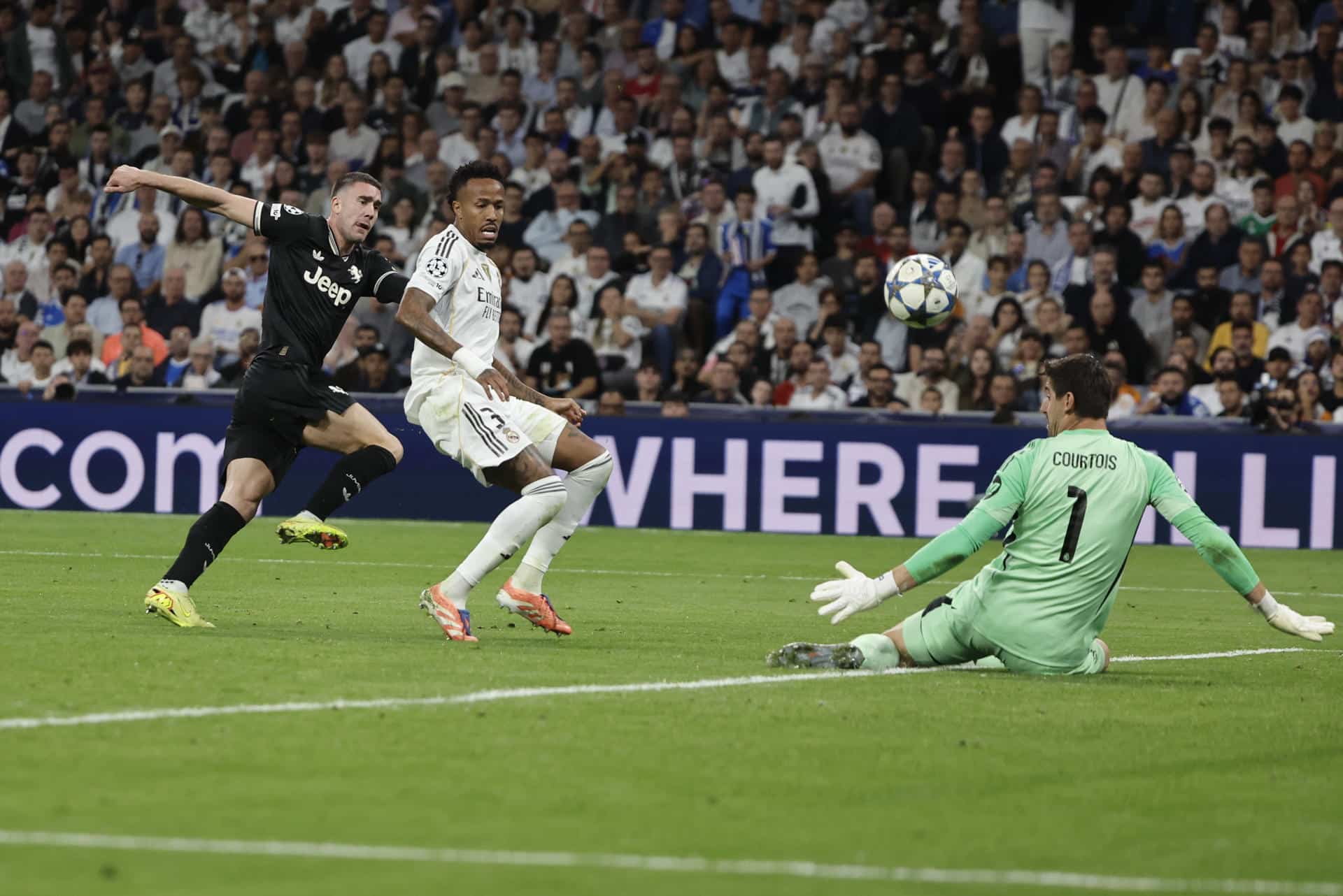 El portero del Real Madrid Thibaut Courtois (d) en acción este miércoles, durante el partido de la jornada 3 de la Liga de Campeones UEFA, entre el Real Madrid y la Juventus, en el estadio Santiago Bernabéu de Madrid. EFE/ Sergio Perez