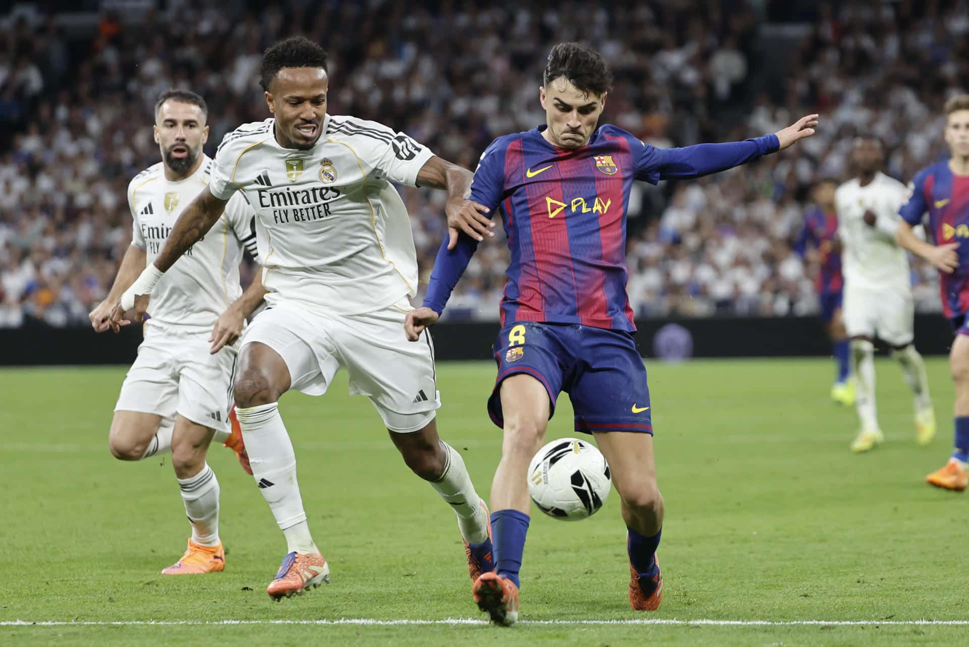 Dani Carvajal (i), durante el partido contra el Barcelona, en una jugada con su compañero del Real Madrid Éder Militão (c) y el centrocampista barcelonista Pedri González (d). EFE/ Sergio Pérez