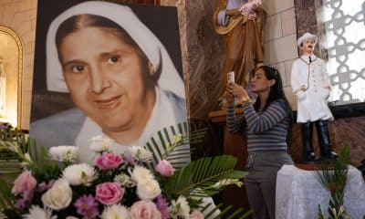 Una mujer toma una fotografía a una imagen de Santa Carmen Rendiles durante una misa en su honor este domingo, en Caracas (Venezuela). EFE/ Ronald Peña R