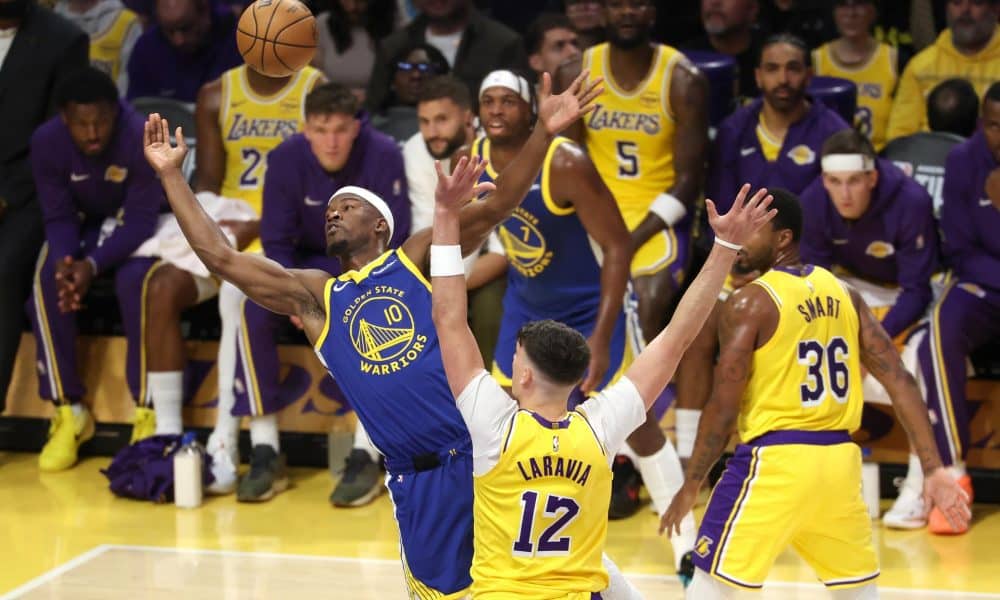 El alero de Golden State Warriors Jimmy Butler (i) lanza el balón ante la oposición de Deandre Ayton (d). EFE/EPA/ALLISON DINNER SHUTTERSTOCK OUT