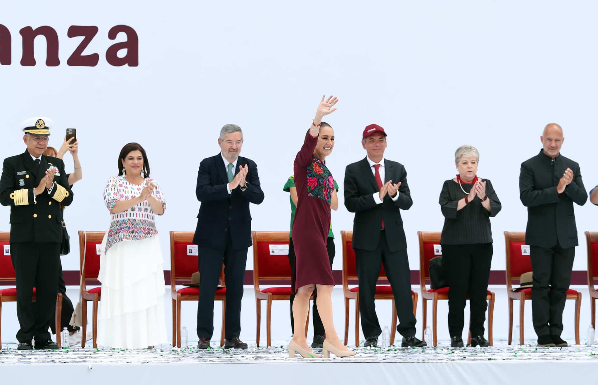 La presidenta de México Claudia Sheinbaum (c), saluda al final de la conmemoración de su primer año de gobierno este domingo, en el Zócalo de la Ciudad de México (México). EFE/Mario Guzmán