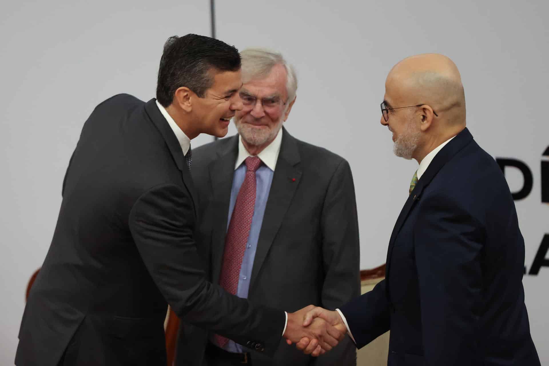 El presidente de Paraguay, Santiago Peña (i), saluda al representante del Banco Interamericano de Desarrollo en Paraguay, Alonso Chaverri Suárez (d), y al presidente del Comité de Competencia de la OCDE, Frédéric Jenny, durante la inauguración del Foro Latinoamericano y del Caribe de la Competencia de la Organización para la Cooperación y el Desarrollo Económico (OCDE) y el Banco Interamericano de Desarrollo (BID) este martes, en Asunción (Paraguay). EFE/ Juan Pablo Pino