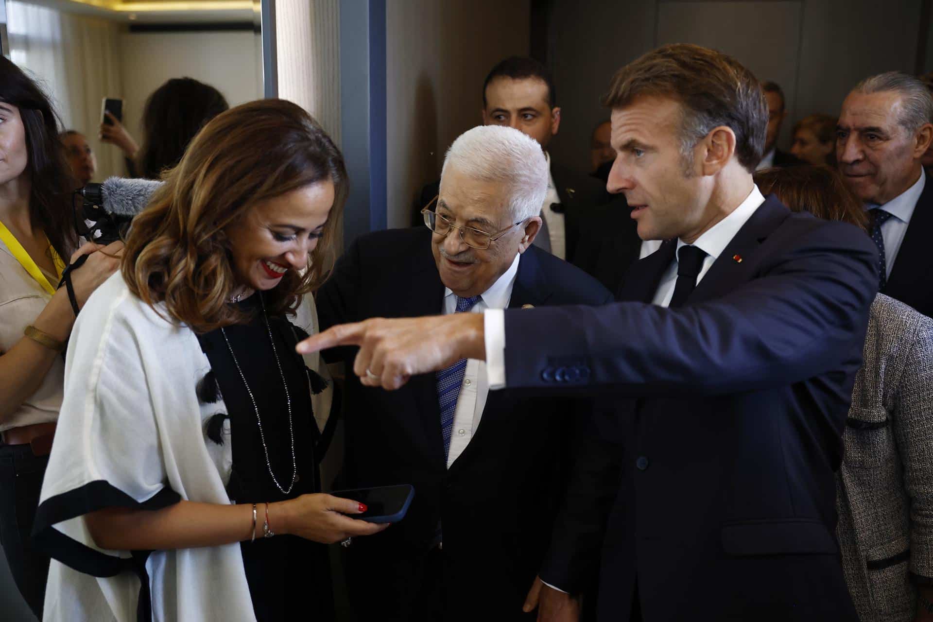 El presidente francés, Emmanuel Macron (derecha) y el de la Autoridad Nacional Palestina, Mahmud Abás (centro) hablan con la parlamentaria francesa Amelia Lakrafi tras su llegada a la ciudad-balneario egipcia de Sharm el-Sheij para la llamada "Cumbre de Paz" sobre Gaza. EFE/EPA/Yoan Valat