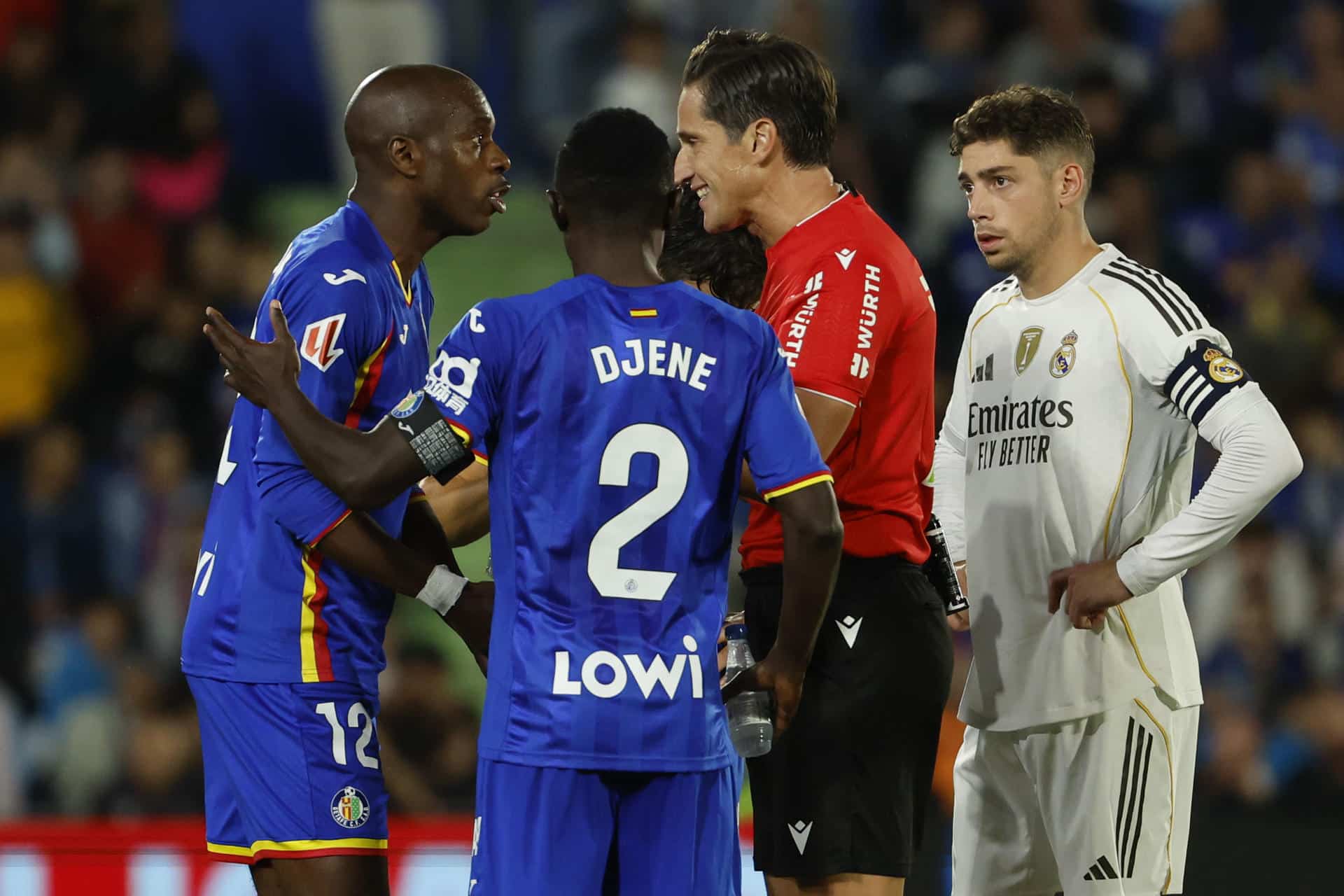 El defensa camerunés del Getafe, Allan Nyom (i), protesta al colegiado Munuera Montero tras ser expulsado durante el partido de la jornada 9 de LaLiga EA Sports que Getafe y Real Madrid disputaron en el Coliseum, en Getafe (Comunidad de Madrid). EFE/Mariscal.