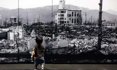 Un niñ camina hacia una gran foto de la ciudad de Hiroshima devastada tras la explosión nuclear. (Japón, Estados Unidos) EFE/EPA/FRANCK ROBICHON