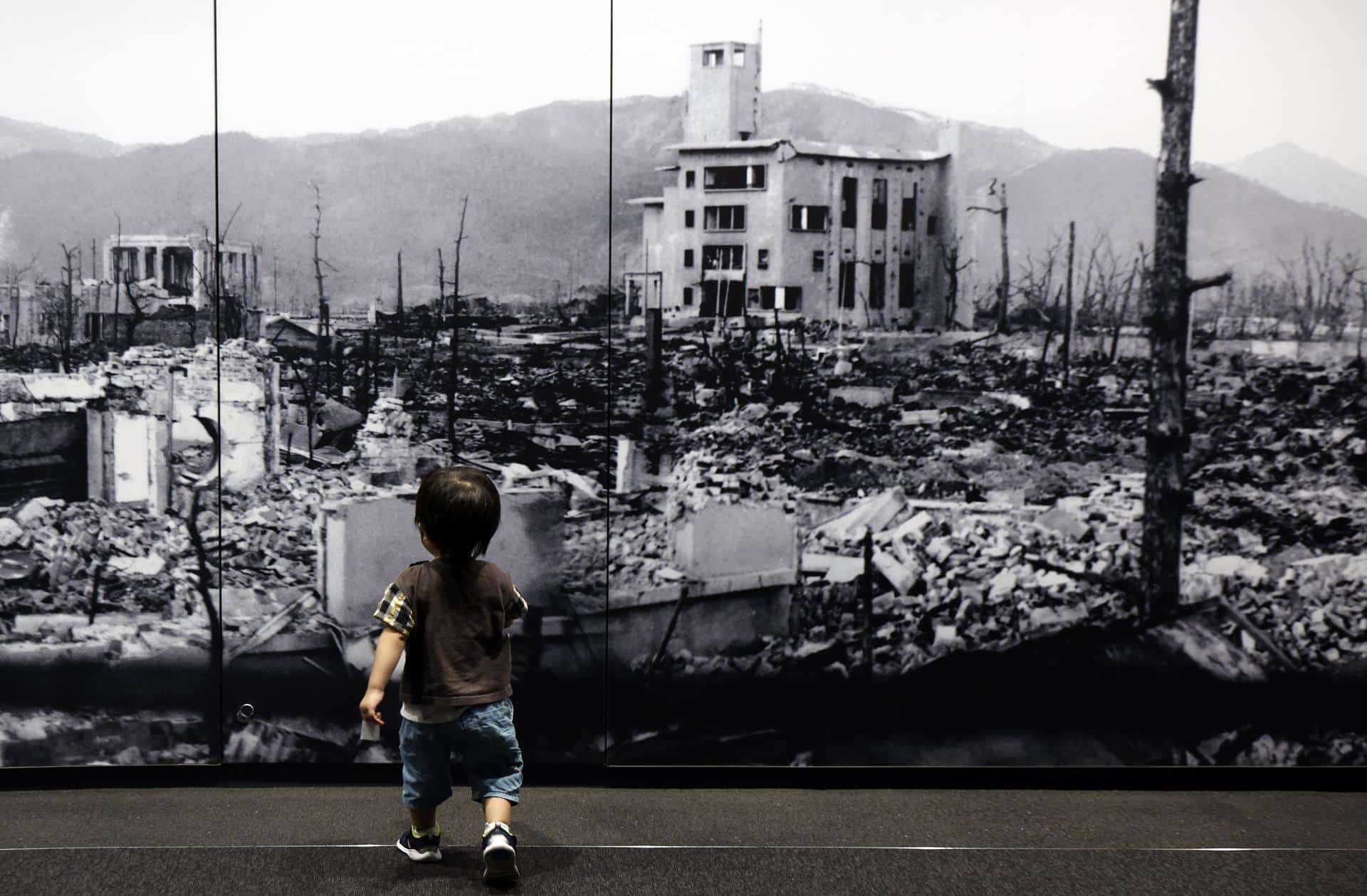 Un niñ camina hacia una gran foto de la ciudad de Hiroshima devastada tras la explosión nuclear. (Japón, Estados Unidos) EFE/EPA/FRANCK ROBICHON