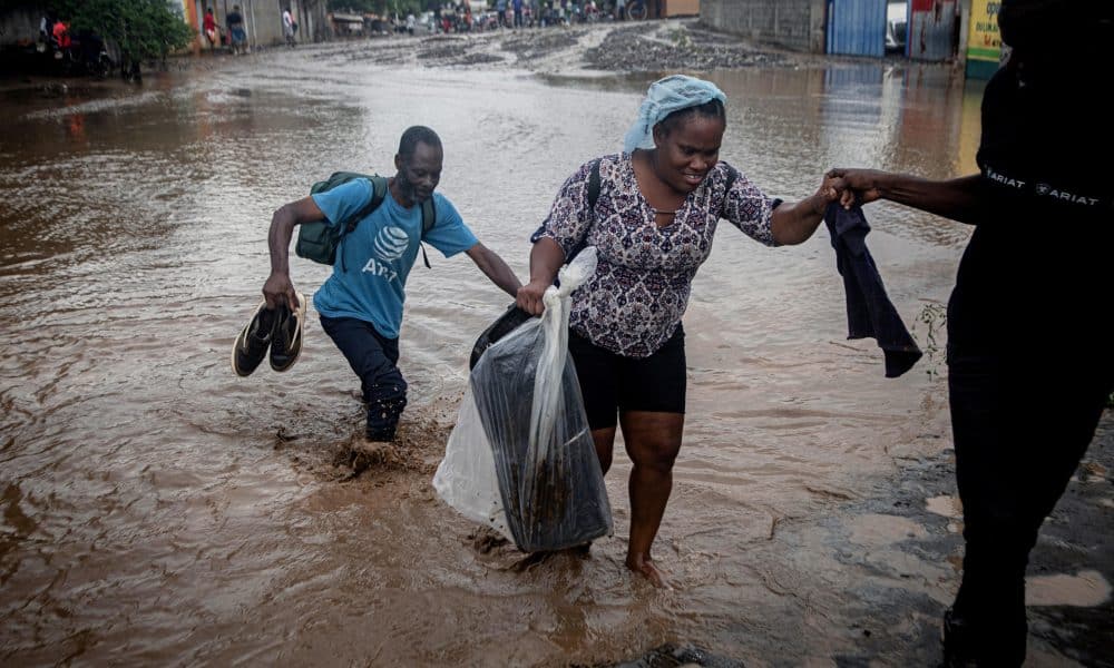 Personas caminan por una calle inundada por el paso del huracán Melissa este jueves, en Petit-Goâve (Haití). EFE/ Mentor David Lorens