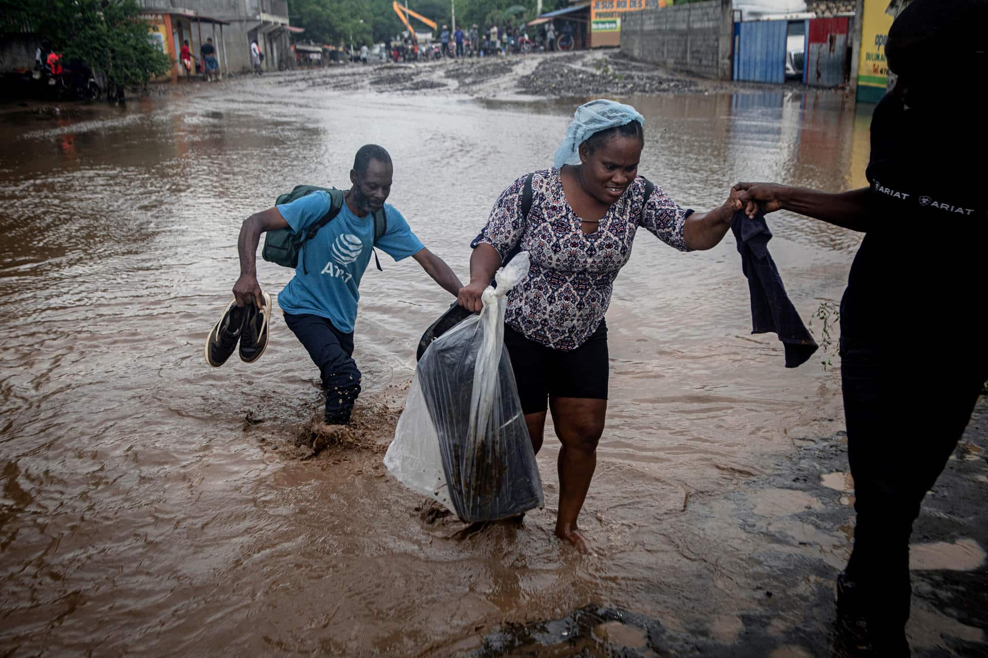 Personas caminan por una calle inundada por el paso del huracán Melissa este jueves, en Petit-Goâve (Haití). EFE/ Mentor David Lorens