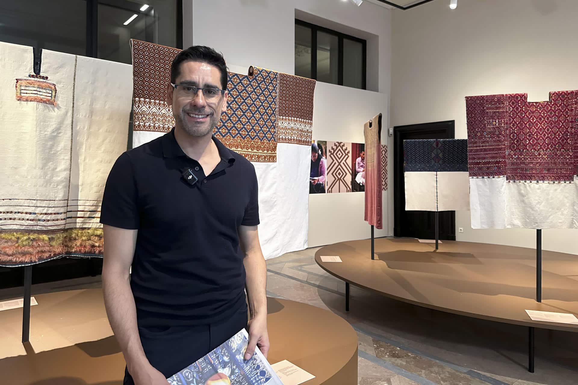 Un proyecto de arte social expuesto en el Museo Etnológico de Viena ('Weltmuseum'), explora a través de los hilos y los colores el concepto del "tiempo" como reliquia ancestral, devolviendo el valor al proceso creativo de artesanas y artesanos tejedores de 30 comunidades indígenas de México. En la imagen, el artista visual mexicano Carlos Barrera junto a la exposición 'Los colores de la tierra' inaugurada esta semana y abierta al público hasta abril de 2026. EFE/ Núria Morchón