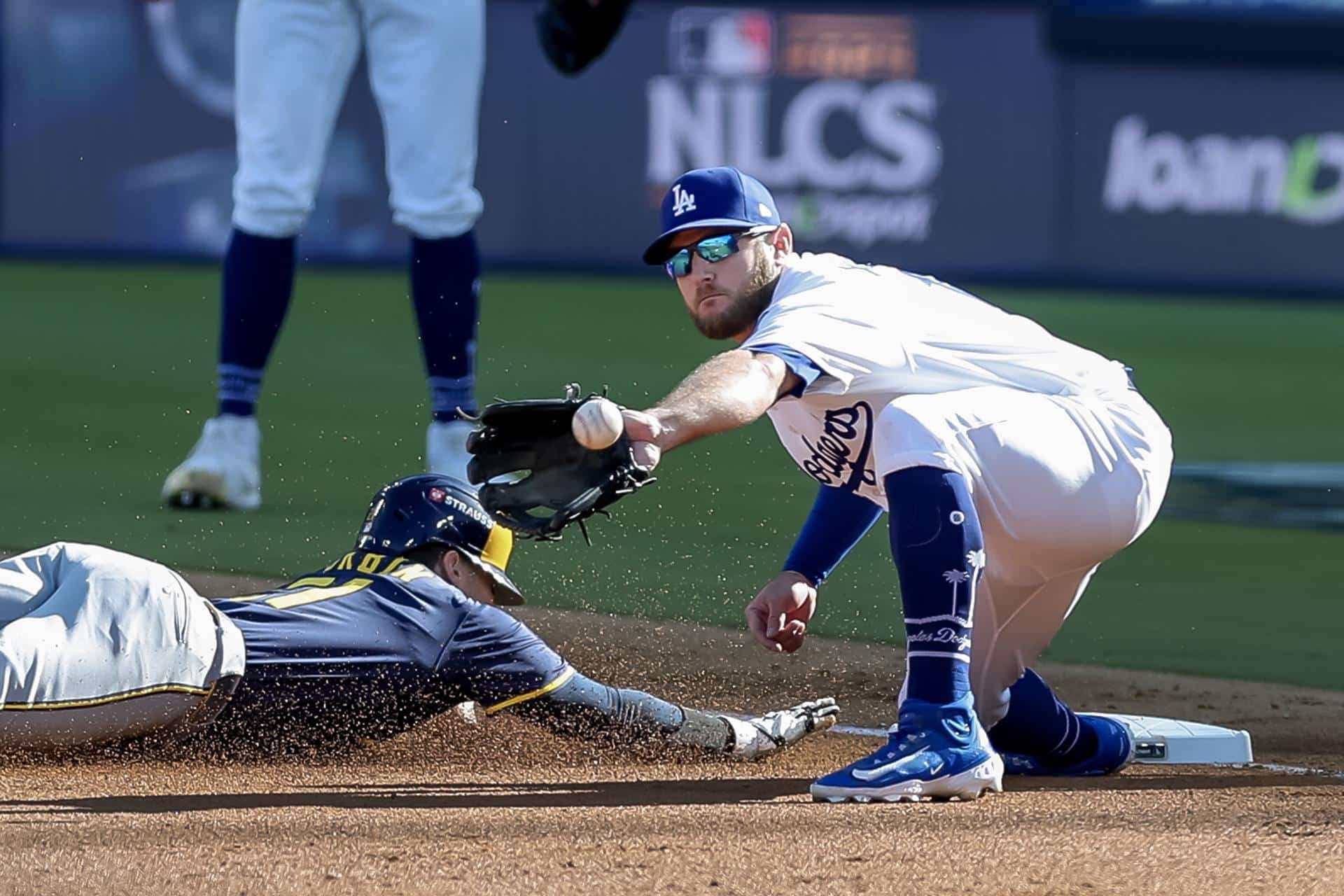 El antesalista de los Cerveceros de Milwaukee Caleb Durbin (i) se desliza a salvo de la captura de Max Dunci de Los Dodgers de Los Angeles, este jueves durante el tercer juego de la Serie de Campeonato de la Liga Nacional, el primero en Los Ángeles (California). EFE/EPA/ALLISON DINNER