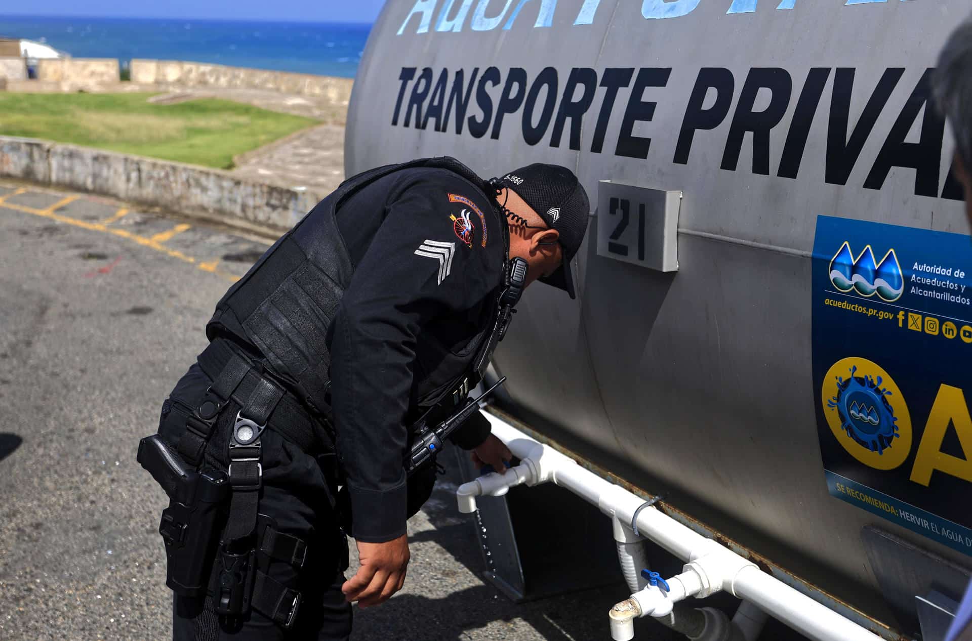 Un agente de la policía revisa una cisterna de agua potable este martes en una calle de San Juan, Puerto Rico. EFE/Thais Llorca