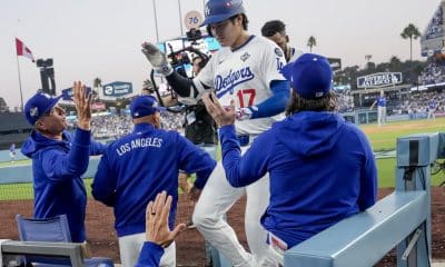 El bateador designado de los Los Angeles Dodgers, Shohei Ohtani (c), es recibido en el dugout después de conectar un jonrón en solitario contra los Azulejos de Toronto durante la tercera entrada del tercer juego de la Serie Mundial de la MLB. EFE/EPA/ALLISON DINNER