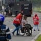 Fotografía tomada de la cuenta en X @SeguridadBOG de la Secretaría de Seguridad de Bogotá de un gestor de convivencia acompañando a una persona en silla de ruedas este viernes, durante una protesta en Bogotá (Colombia). EFE/ Secretaría de Seguridad de Bogotá