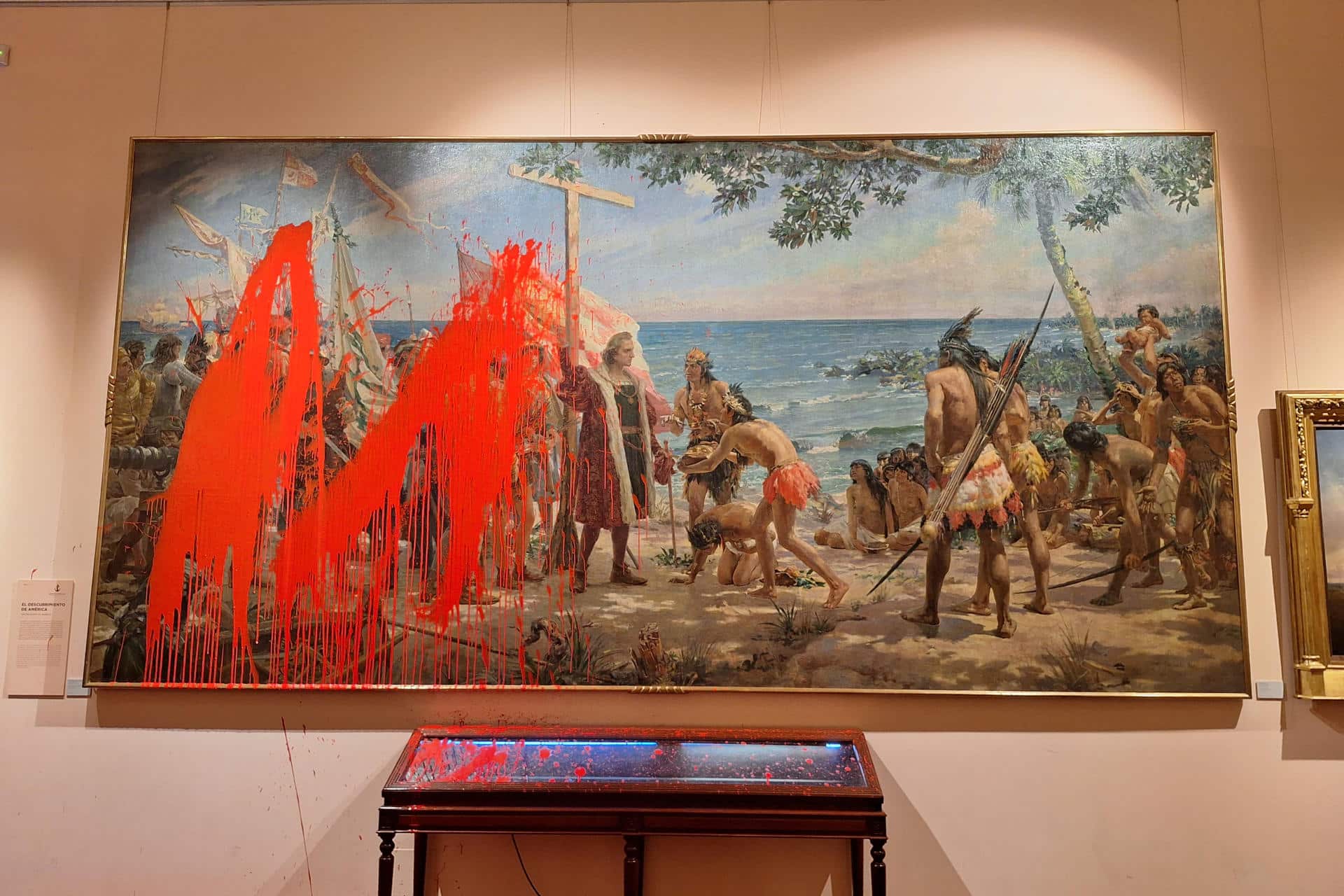 MADRID, 12/10/2025.- Dos activistas del movimiento de desobediencia civil no violenta Futuro Vegetal han lanzado este domingo pintura roja biodegradable sobre un cuadro en el Museo Naval de Madrid, en un acto de protesta por la celebración de la Fiesta Nacional y para denunciar el actual neocolonialismo extractivista que explota sus recursos naturales. EFE/ Gaspar Ruiz-canela